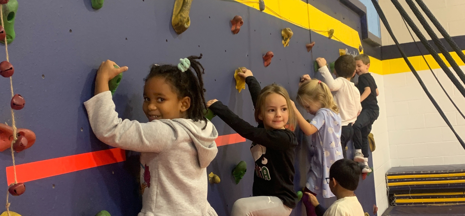 Students climbing the rock wall in PE