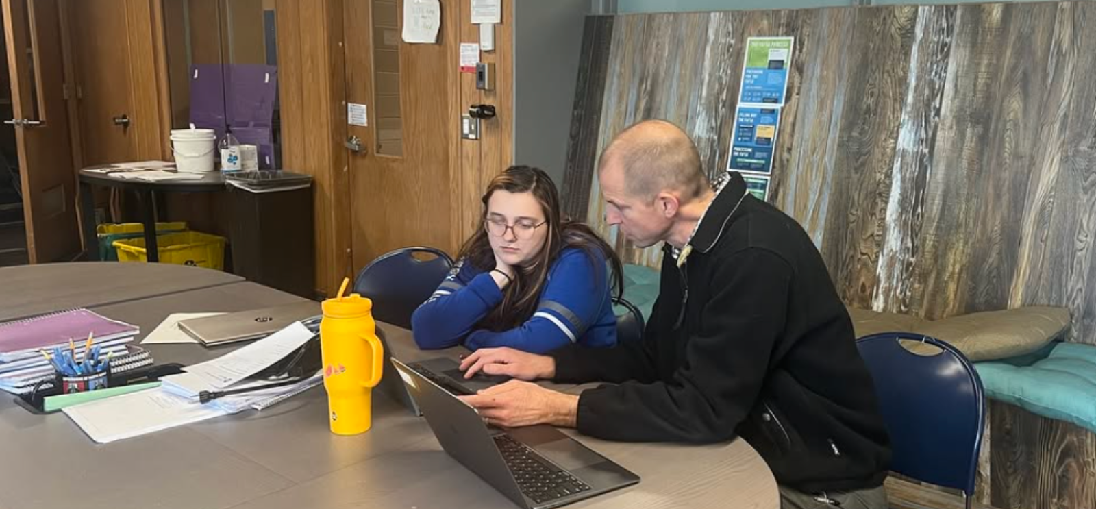 Student and teacher collaborating on a laptop computer