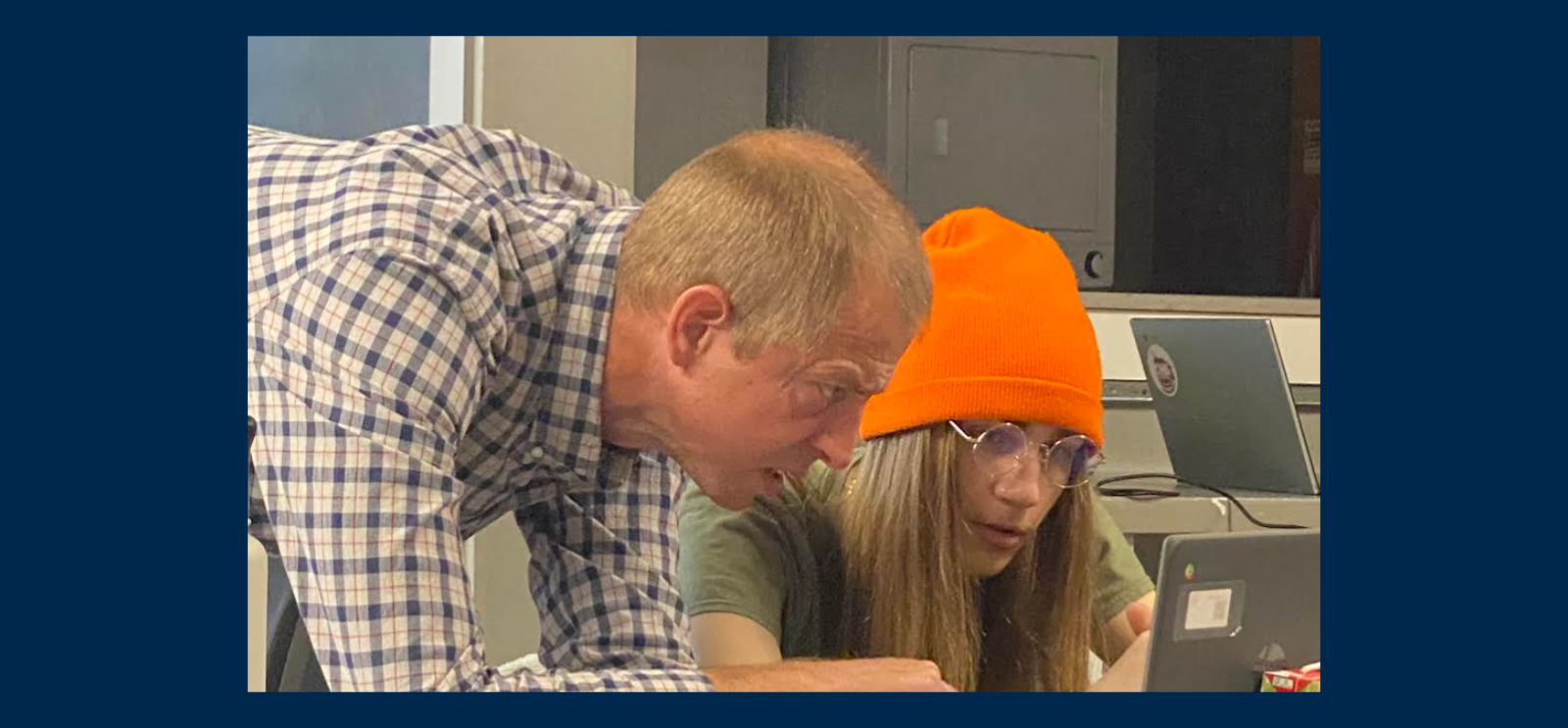 Student and teacher collaborating on a laptop computer