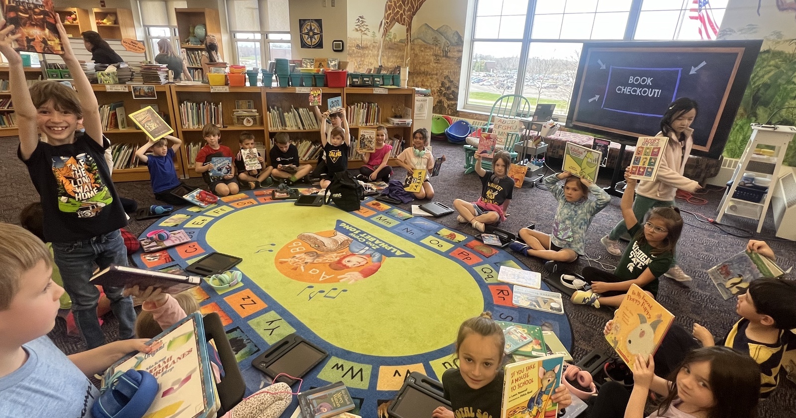 Students in the Harvest Media Center showing their books