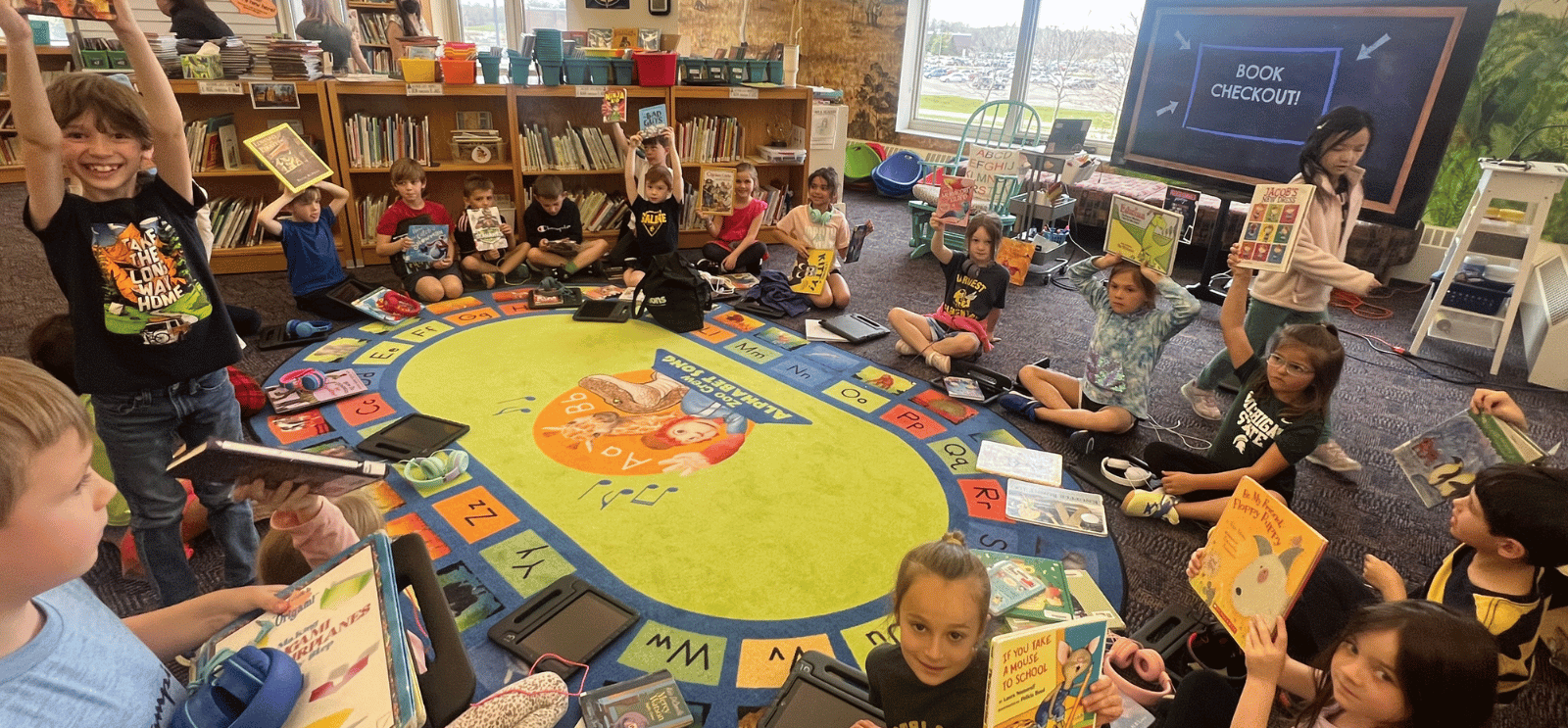 Students in the Harvest Media Center showing their books